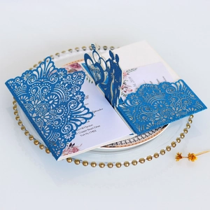 Detail of laser-cut glitter wedding invitation with romantic silhouette and floral lace