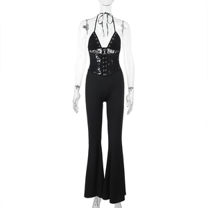 Detail of black lace halterneck jumpsuit showing slim fit bodice and flared leg pants