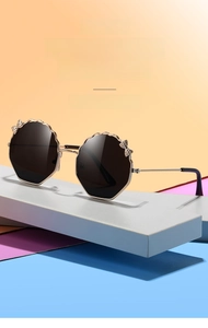 Détail de la monture de lunettes dorée à bords ondulés avec décoration de nœud pour enfants