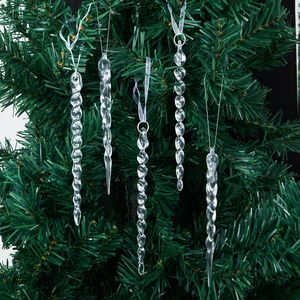 Set of clear acrylic spiral icicle ornaments hanging on a green Christmas tree