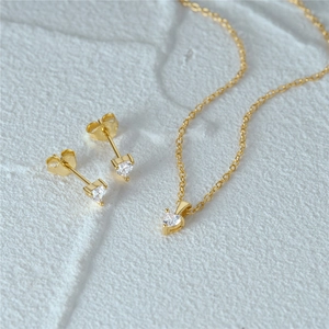 Detailed macro view of S925 sterling silver stamp on golden heart jewelry set with zircons