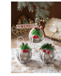 Detailed view of linen Christmas balls with pine needles, red berries and snow patterns