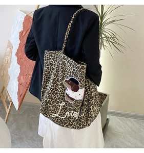 Back view of a leopard print tote bag with dog embroidery on a female shoulder