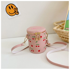 Close-up of pink cherry bucket bag with floral zipper pull and adjustable shoulder strap