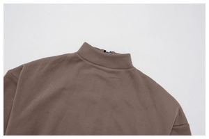 Macro detail of dark brown quarter-zip collar and durable stitching on warm sports top
