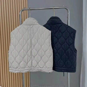 Quilted stand collar vest jackets for women in beige and navy blue displayed on hangers