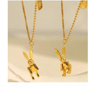 Macro shot of golden mechanical rabbit pendants with lucky engraving on ball chains