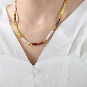 Macro shot of Bohemian handmade beaded necklace with colorful beads on model neckline