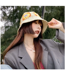 Close-up of a hand-knitted beige bucket hat with sunflower floral embroidery detail