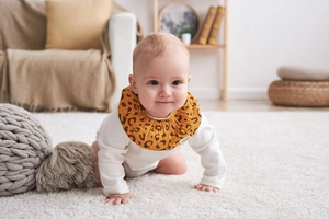 Detail of baby leopard print cotton bib featuring soft petal collar design for newborns