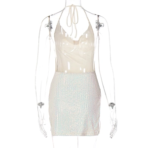 Detail of sequins on a white mini skirt and off-white halter top on a mannequin
