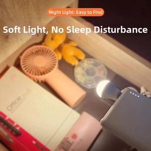 Macro detail of warm white USB night light illuminating a drawer next to laptop