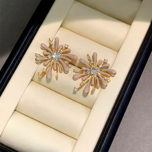 Detail of flower stud earrings with cream enamel and sparkling cubic zirconia stones
