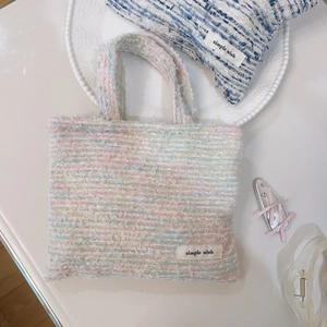 Vista dall'alto di una borsa in tweed color macaron con pochette coordinata