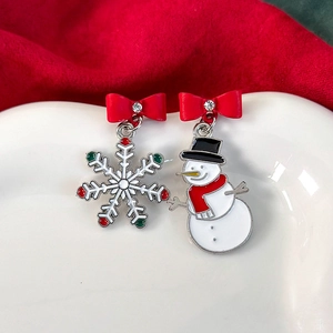 Nahaufnahme asymmetrischer Weihnachtsocher Weihnachtsohrringe mit Schneemann und Schneeflocken-Emaille
