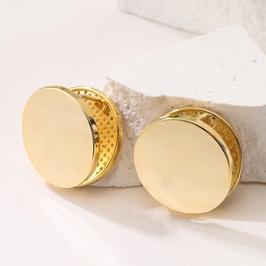 Minimalist gold plated geometric round stud earrings on a decorative stone base