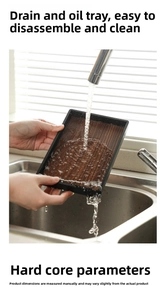 Close-up of a detachable black kitchen drain tray being rinsed to show easy cleaning