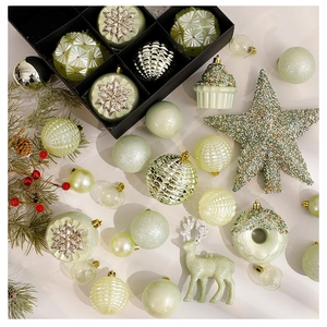 Flat lay of sage green Christmas ornaments including stars and deer shapes in a gift box