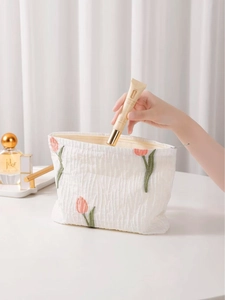 Elegant white seersucker cosmetic bag with pink tulip embroidery and zipper closure