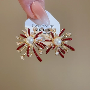 Macro shot of S925 silver firework studs with red enamel and lustrous white pearl