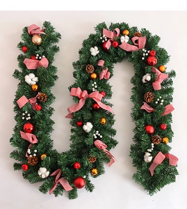 Detail of Christmas garland with pine cones, red bows and decorative cotton balls