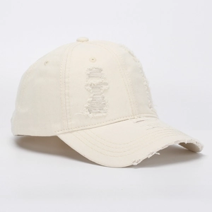 Close-up of distressed beige denim baseball cap with vintage frayed edges and torn details