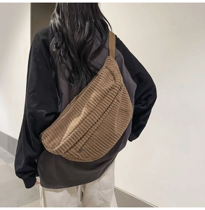 Close-up of brown corduroy crossbody bag texture and adjustable shoulder strap detail