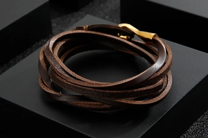 Detail of multi-layer brown leather wrap bracelet with a gold metal fishhook clasp