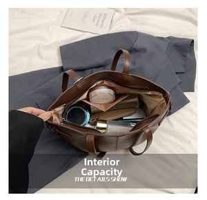 Spacious interior of a dark brown matte leather tote bag with various daily essentials