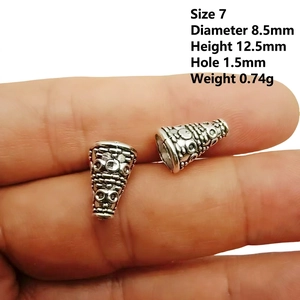 Detailed view of an antique silver alloy bead cap with intricate embossed floral patterns