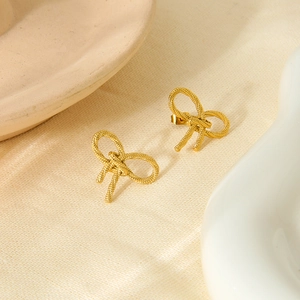 Detailed close-up of 18K gold plated stainless steel bow earrings with woven texture