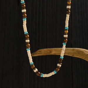 Close-up of bohemian surfer necklace with turquoise, wood beads and shell discs
