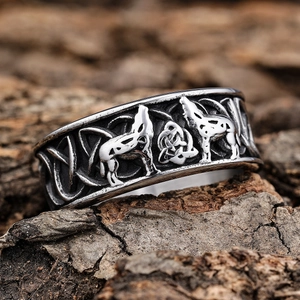 Macro detail of Viking wolf ring with Celtic knot carvings on rustic wood texture