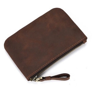 Detailed close-up of dark brown genuine leather coin purse with stitching and zip detail