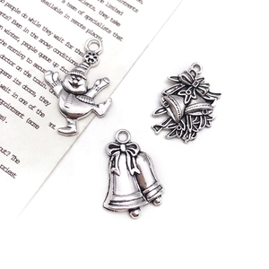 Close-up of vintage silver Christmas alloy charms with snowman and bell designs for DIY