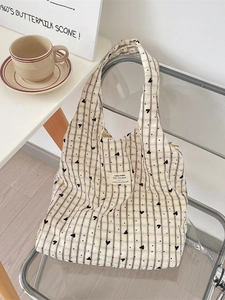 Minimalist canvas tote bag with heart print and vertical stripes on a stylish chair