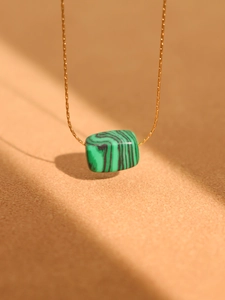 Detailed view of rectangular green malachite pendant on thin 18K gold-plated chain
