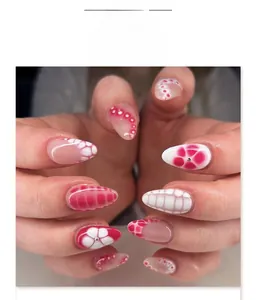 Close-up of almond press-on nails with red floral patterns and checkered designs