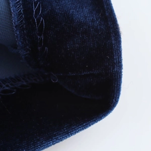Close-up of high-quality stitching and texture on navy blue velvet midi dress fabric