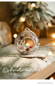 Macro shot of glass Christmas ornament featuring a miniature deer and mushroom landscape