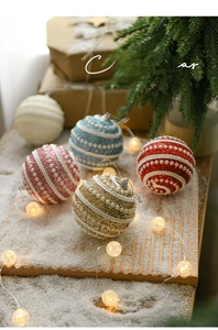 Detailed view of pearl-studded Christmas balls with glitter finish in festive warm setting