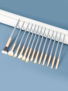 Close-up of 14 professional eye makeup brushes with matte blue handles and rose gold ferrules