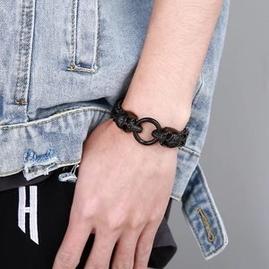 Detail view of men's black punk skull bracelet with central ring clasp on model wrist