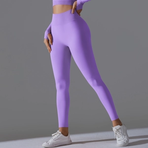 Detailed side view of purple high-waisted seamless yoga pants on a fitness model