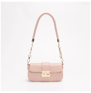 Close-up of pink crocodile texture leather with gold metal clasp and chain strap detail
