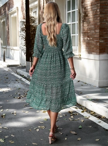 Rear view of a green floral maxi dress featuring tiered skirt and square neckline