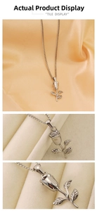 Macro detail of a silver rose flower pendant with finely engraved petals and leaves