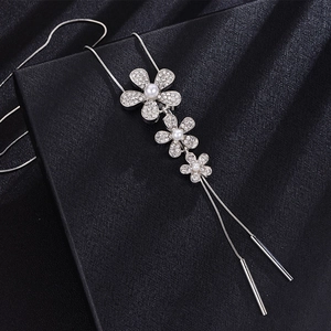 Silver long necklace with crystal flower pendants and white pearls on black silk backdrop