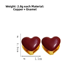 Detail view of heart-shaped gold-plated copper earrings with red enamel coating and measurements