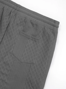 Détail du jogging en maille jacquard gris foncé avec taille élastique et poche plaquée